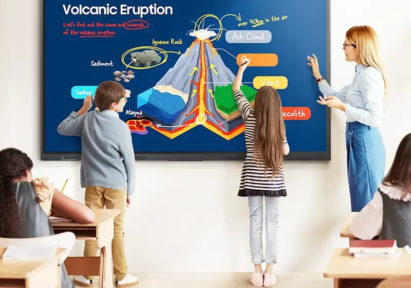 Pupils working at an interactive display in a classroom