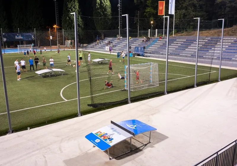 TEQ table beside a floodlit sports court